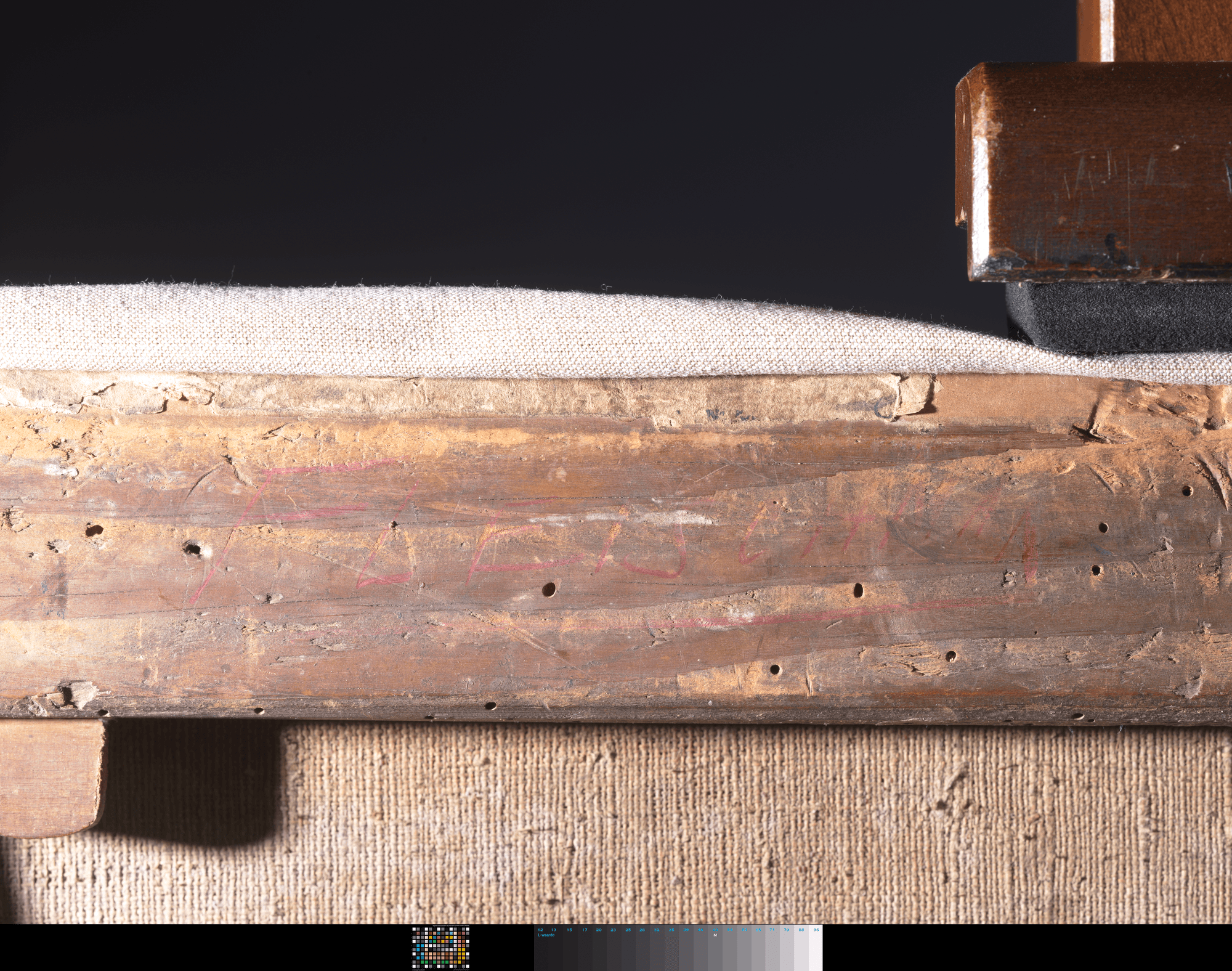 Detailopname van een schilderijlijst beschreven met onleesbaar rood krijt