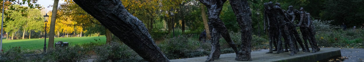 Een deel van de bronzen beelden van het Nationaal Monument Slavernijverleden met in de achtergrond het Amsterdamse Oosterpark