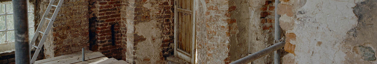 ruw baksteen metselwerk en oude houten deur en steigerpalen tijdens een restauratie,