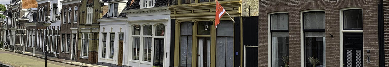 Foto van straat met historische huizen en gracht in Bolsward, Friesland