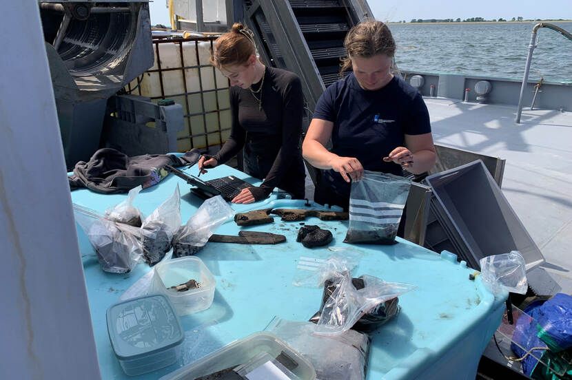 Archeologen bekijken en verwerken vondsten aan boord van een schip