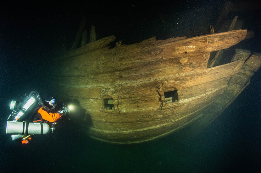 Onderwater foto van een duiker bij het Zeventiende-eeuws Nederlands fluitschip in Finse Golf