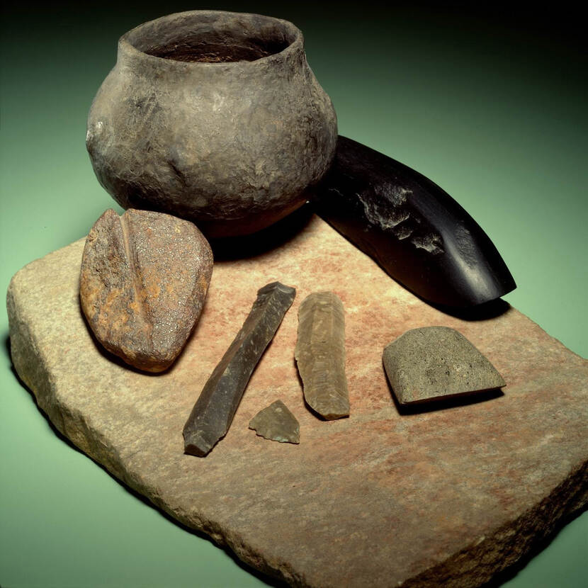 Foto met diverse vondsten uit Graf 87, Elsloo: een kookpot, stenen en werktuigen
