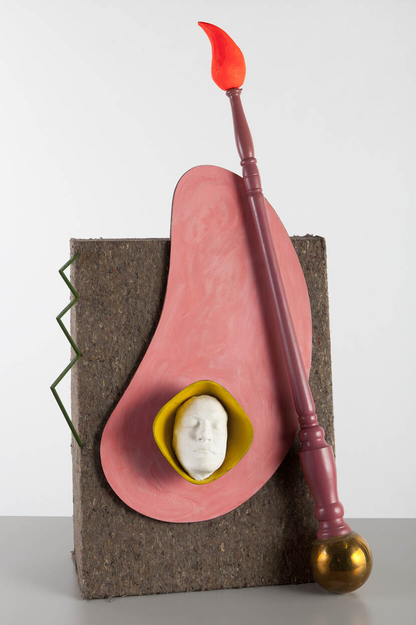 Assemblage van een gipsen masker in houten schaal, een paars geverfde, houten penseel met fel oranje kwast en bolvormige, messing knop, een roze palet en een metalen zigzag, op een schuine, doosvormige achterwand die met grijs gemêleerd vilt bekleed is.