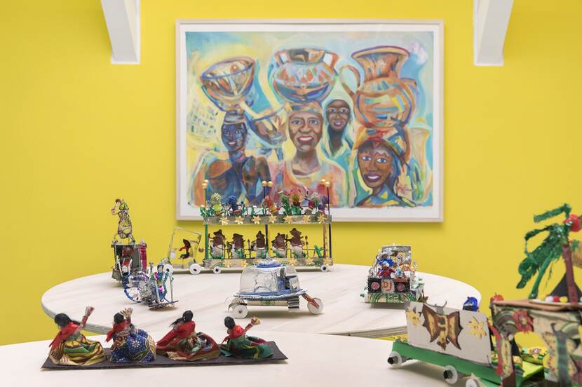 Foto met kleine praalwagens en een schilderij met het thema zomercarnaval