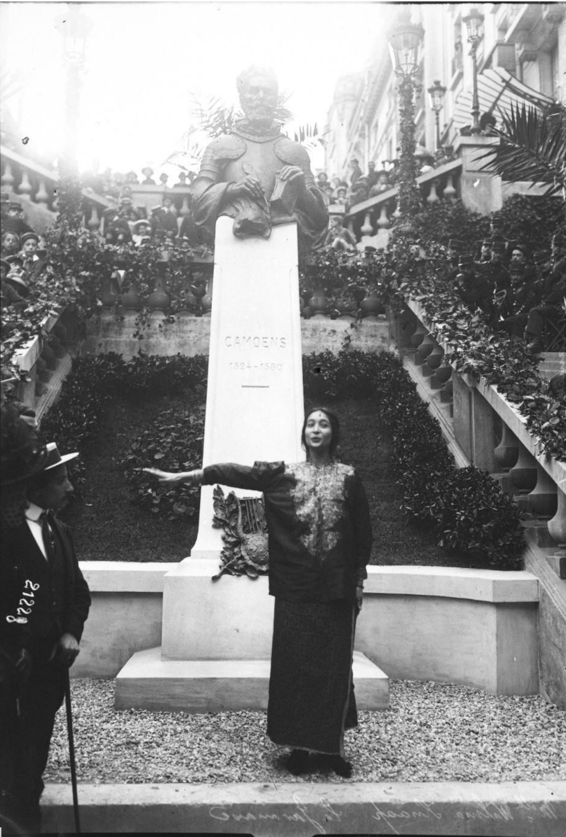 Zwart-wit foto van een jonge vrouw die voor een monument staat