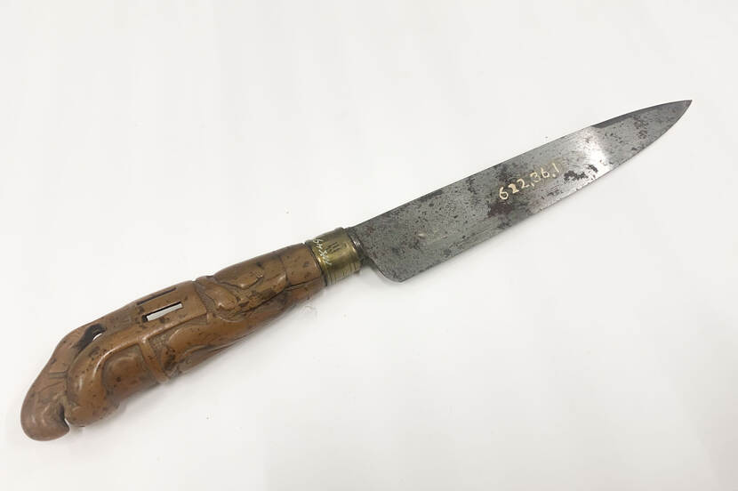 Foto van een mes. Mes, lemmet van staal waarin inscriptie E. Quincke en gesneden heft van fruitbomenhout met een klimmend leeuwtje als bekroning