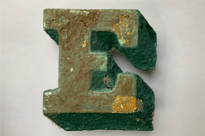 De letter E, gemaakt van zink en beschilderd.
