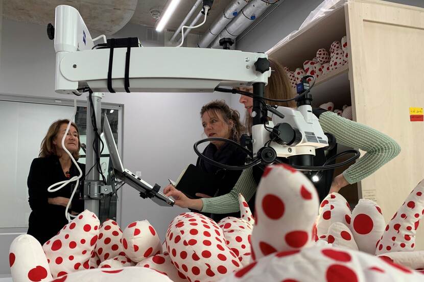 Drie onderzoekers bij een kunstwerk van Yayoi Kusama