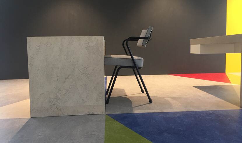 tafel en bureau stoel en gekleurde vloer in vlakken, ontwerp van Rietveld.