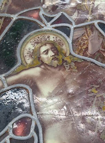 Detail van een neogotisch glas-in-loodraam met Marie en Johannes die het dode lichaam van Christus bewenen