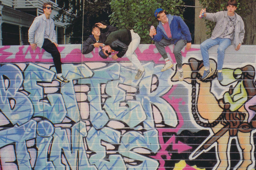 Jonge graffitiartiesten in de jaren '80 op een muur met graffiti