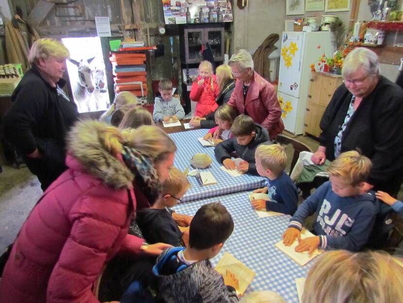 Jonge buurtbewoners aan tafel in de Fronikboerderij