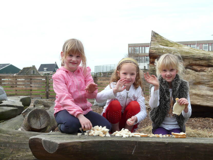 Jonge kinderen maken het brood klein om de dieren bij de Fronikboerderij te voeren