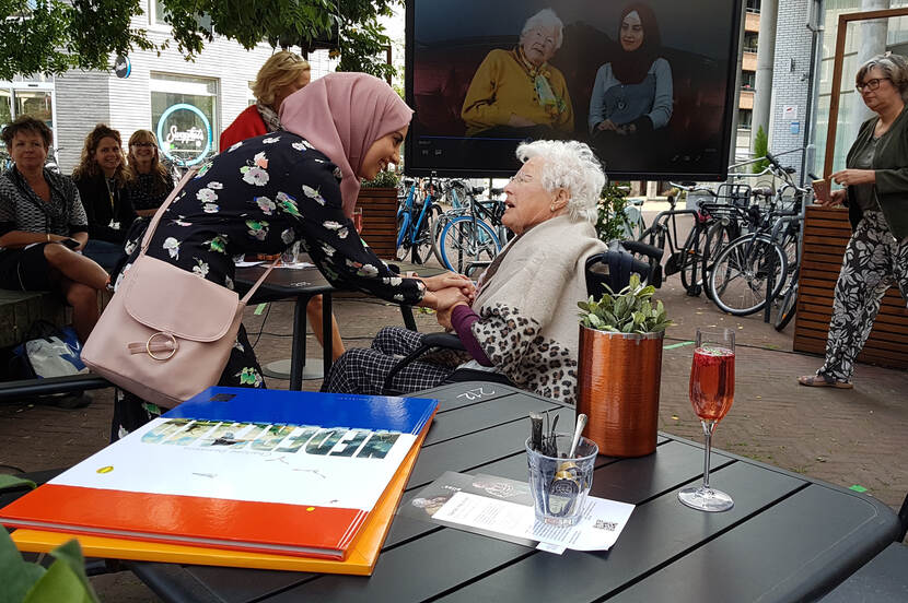 Deelnemers Inas en Henny ontmoeten elkaar weer na een jaar tijdens de opening.