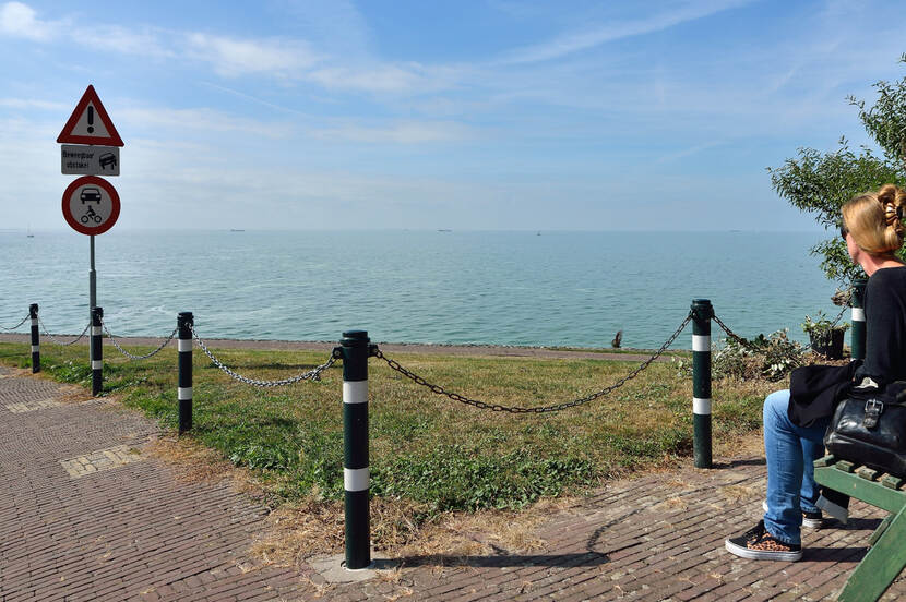 Vrouw kijkt uit over het IJsselmeer