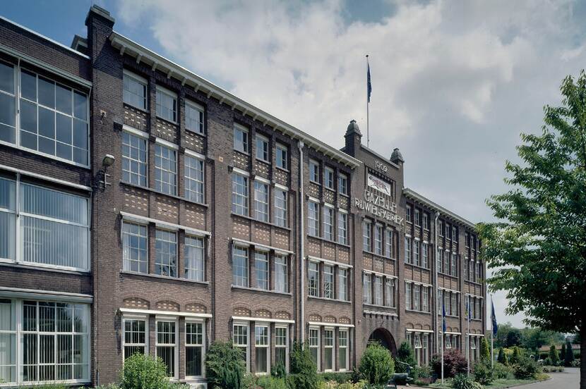 Zicht op de voorgevel van een monumentale fabriek.