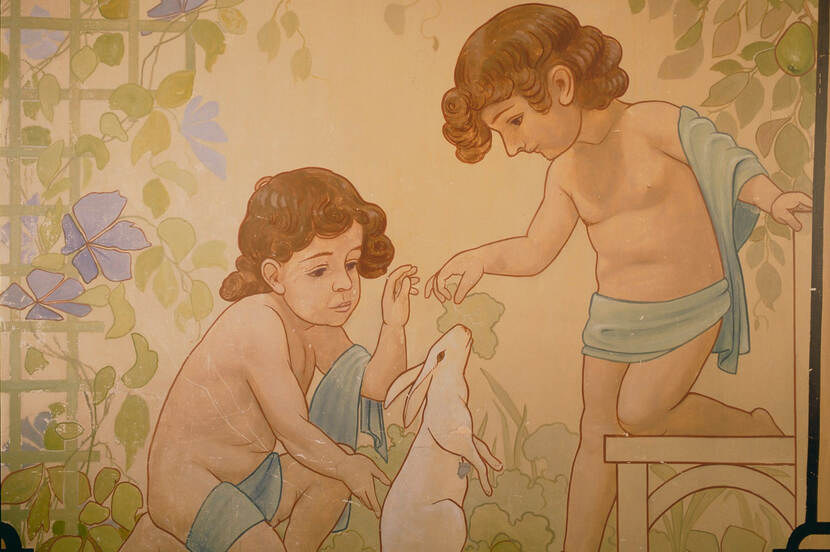 Muurschildering op de overloop, twee kinderen voeren een konijn