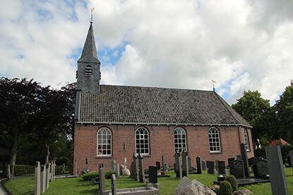 eenvoudige kerk met kleine toren met op de voorgrond grafmonumenten