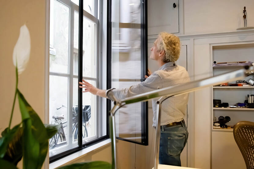 Foto van een man die een raam sluit
