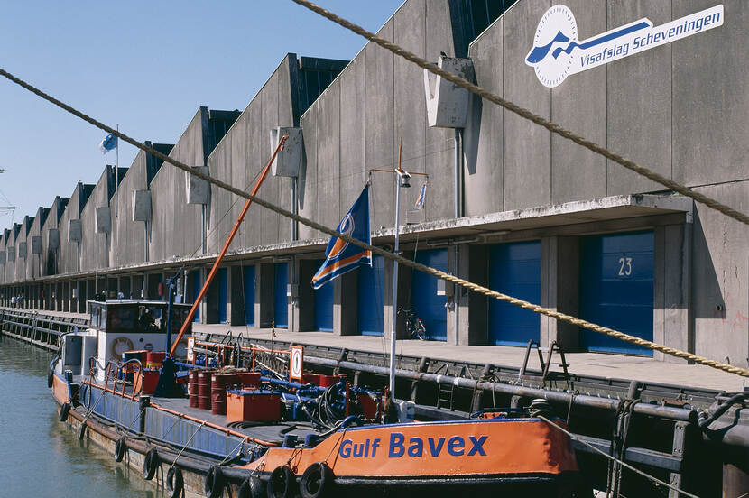 Visafslag in Scheveningen. Op de voorgrond een groot schip.