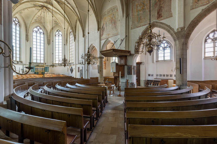 Interieur van de protestantse kerk in Aalten met gebogen kerkbanken en een kansel