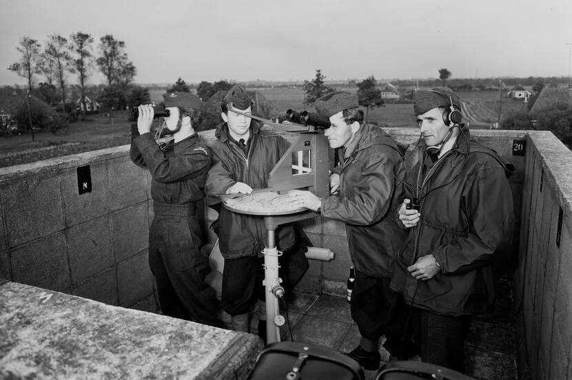 Zwartwit foto van personeel van het Korps Luchtwachtdienst wat de hemel afspeurt vanaf de luchtwachttoren Oudega, Smallingerland