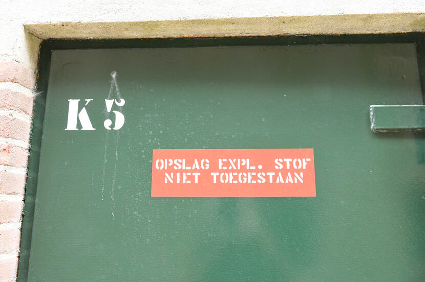 Foto van een waarschuwing in Fort Honswijk, met de tekst: K5 - Opslag Expl. Stof Niet Toegestaan"