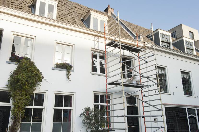 Foto van monumentaal woonhuis met een steiger er voor, tijdens schilderwerkzaamheden