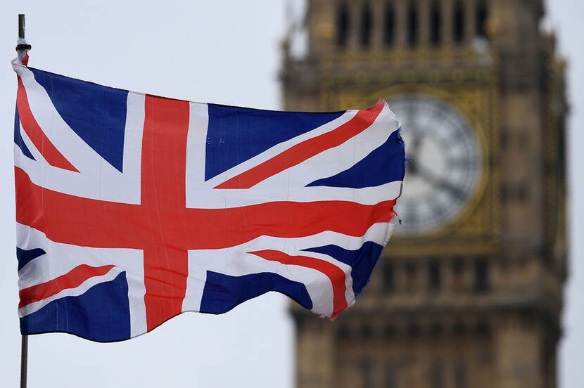 De vlag van het Verenigd Koninkrijk met de Big Ben in de achtergrond (onscherp)