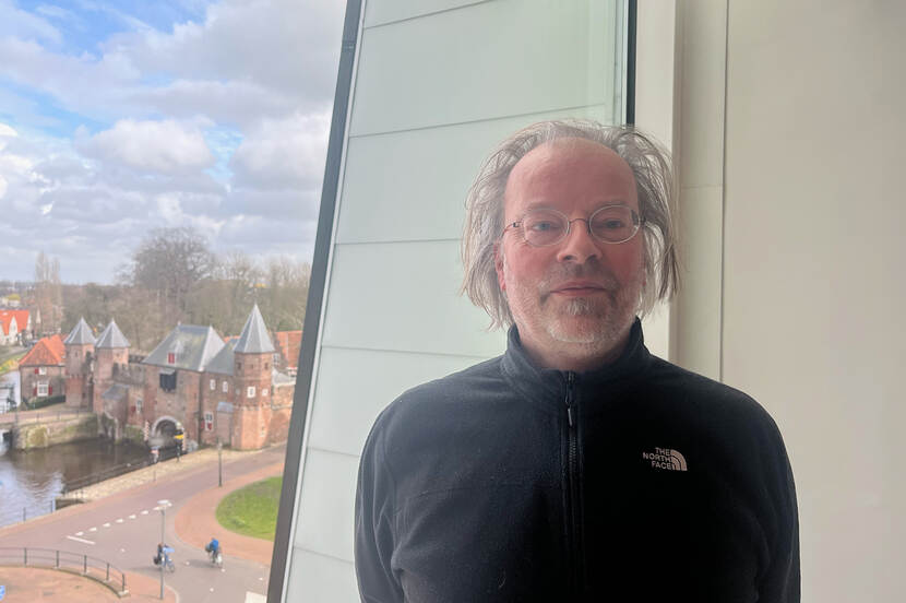 portret van Jaap Evert Abrahamse met in de achtergrond de historische Koppelpoort van Amersfoort