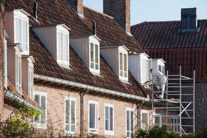 Foto van man aan het werk aan een monument op een steiger