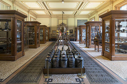 Grote museumzaal van Teylers Museumoverzicht met instrumenten in het midden