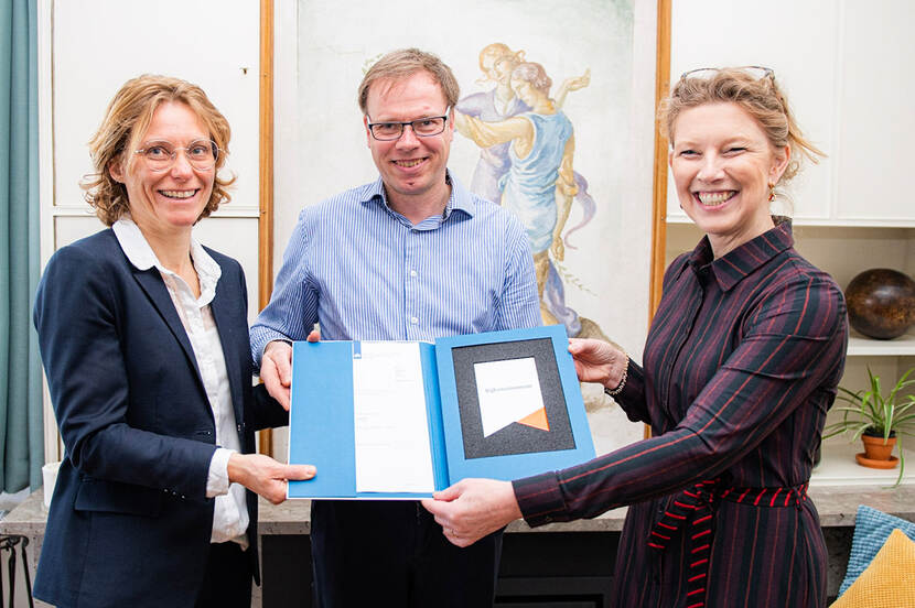 Mevrouw en de heer Meijerink ontvangen uit handen van Susan Lammers het Rijksmonumentenschildje en bijbehorende documenten.