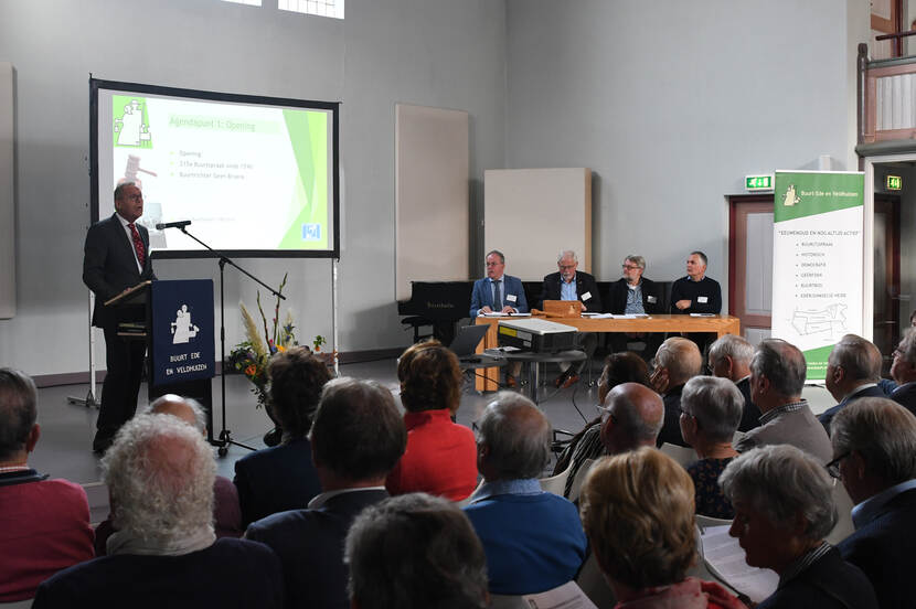 Opening van de jaarlijks Buurtspraak door de Buurtrichter de heer Broere. Op het podium de leden van het Buurtbestuur.