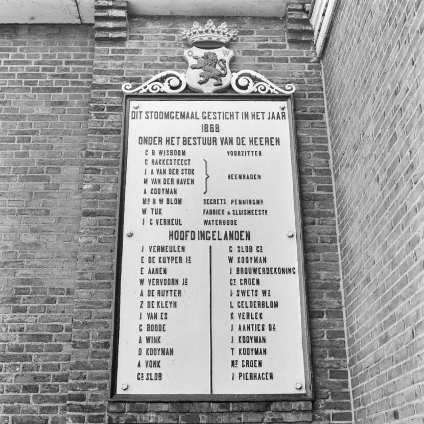 Zwart-wit foto van een plaquette waarop staat: 'Dit stoomgemaal gesticht in het jaar 1868', met daaronder de namen van het bestuur.