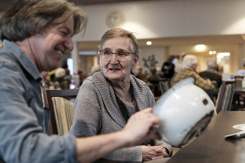 Foto van twee mensen die een po van emaille bekijken