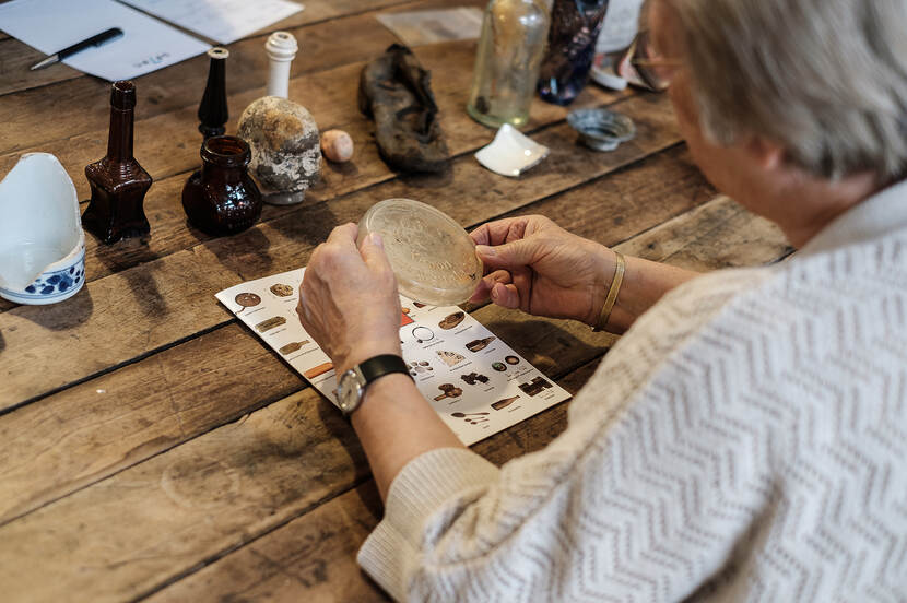 Foto van een vrouw die een weckpotdeksel bekijkt