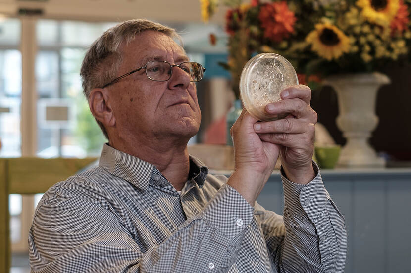 Man bekijkt aandachtig een oude weckpotdeksel