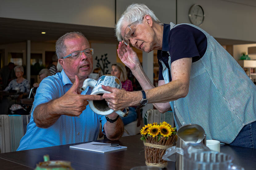 Man en vrouw bestuderen oude thee- of kofiiepot