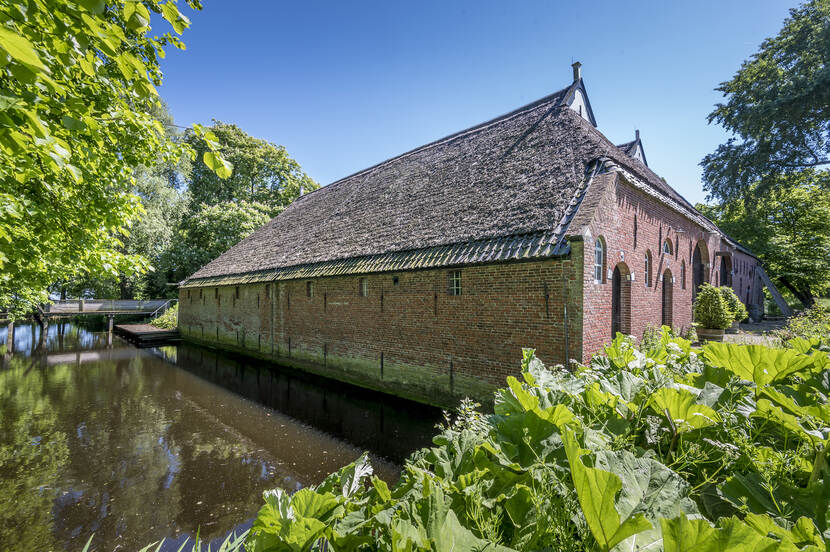 foto van de zijgevel van Melkema Huizinge langs het water, voor herstel