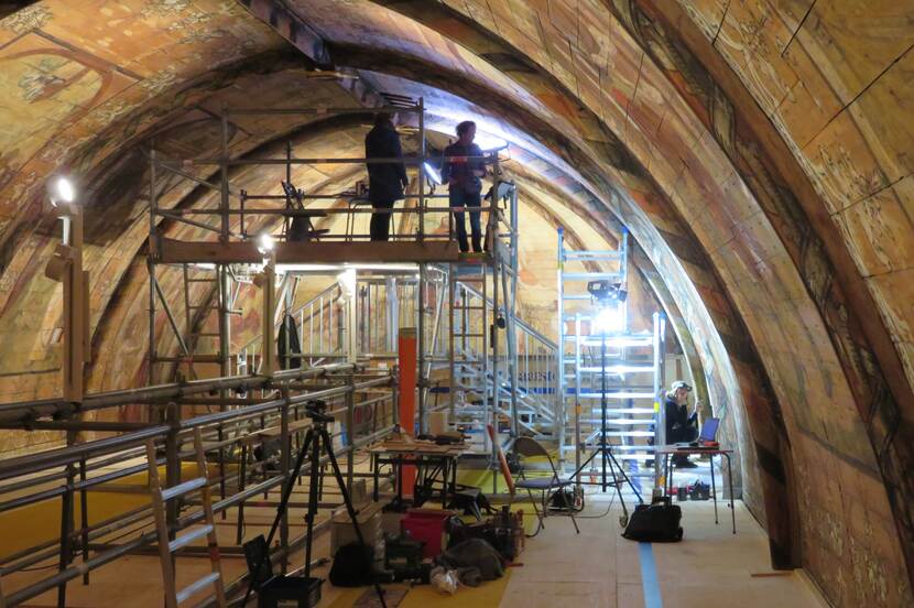 Restauratoren doen onderzoek aan de schilderingen van de Grote Kerk vanaf de steigervloer