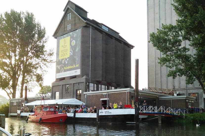 Een culinair feestje bij De Zwarte silo aan het water, met mensen op het terras