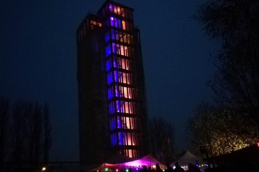 Avondfoto van de grijze silo met opvallende verlichting