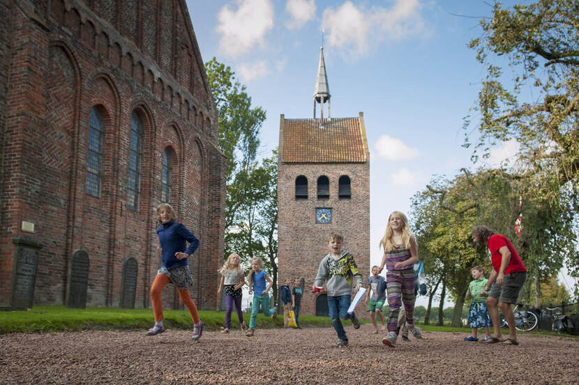 Kinderen spelen op een plein voor een kerk.