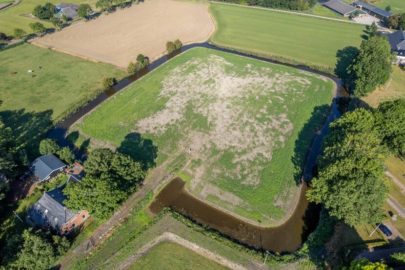 Luchtfoto van landschap met gracht waar vroeger de Onstaborg stond