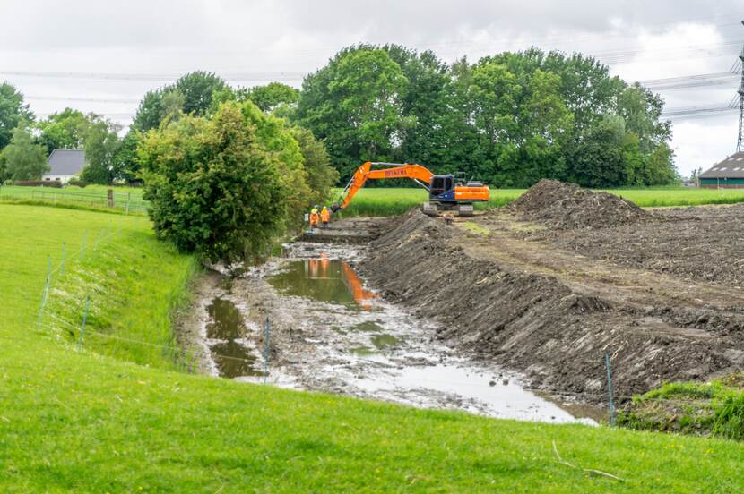 Een stuk gras en een sloot met werkzaamheden