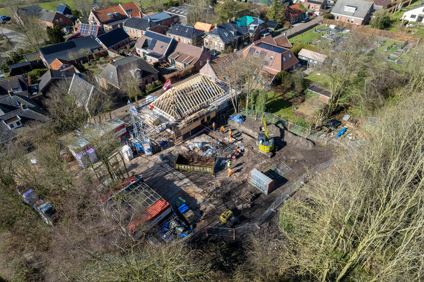 Bovenaanzicht van het voorhuis in Rottum dat van een nieuw dak wordt voorzien met daarnaast de archeologische vindplaats.