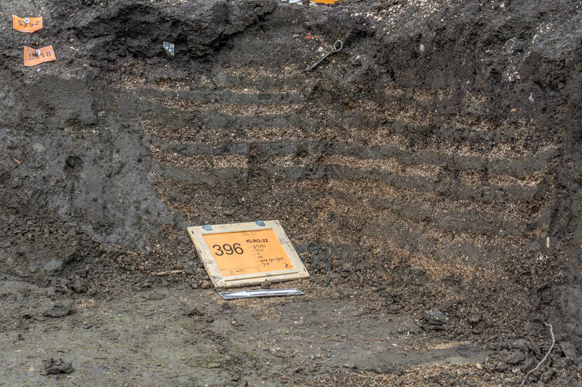 Een foto van de grondverbetering voor de fundering van de voormalige kerk, die een spekkoek-patroon in laagjes laat zien.
