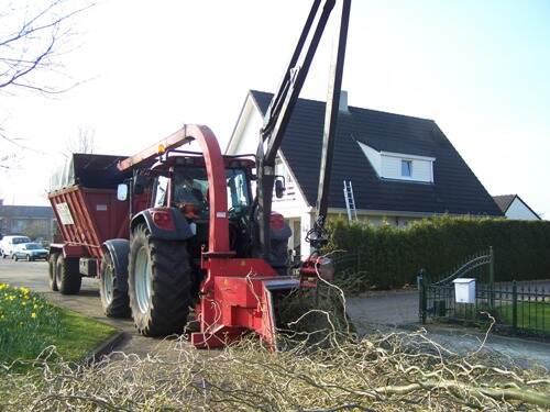 Een tractor pleegt onderhoud langs een singel